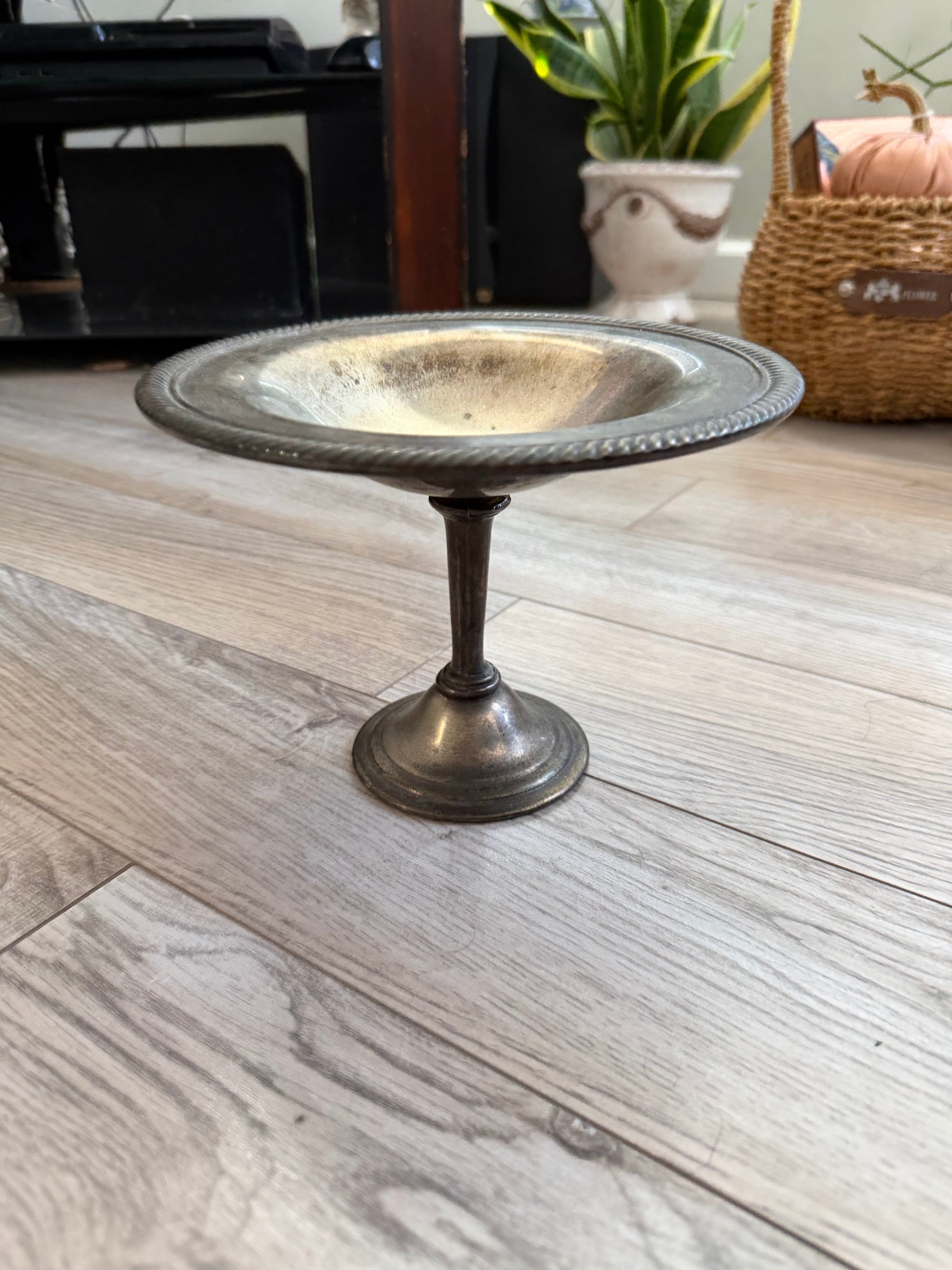Vintage silverplate pedestal compote on wood floor, side view