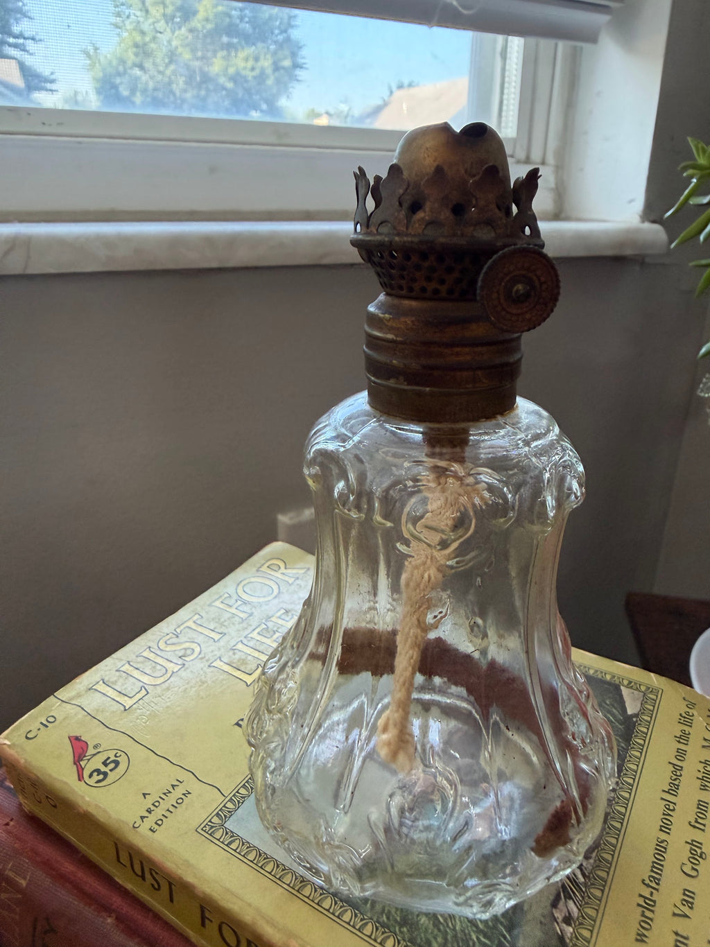 Miniature oil lamp showing embossed scroll pattern on font