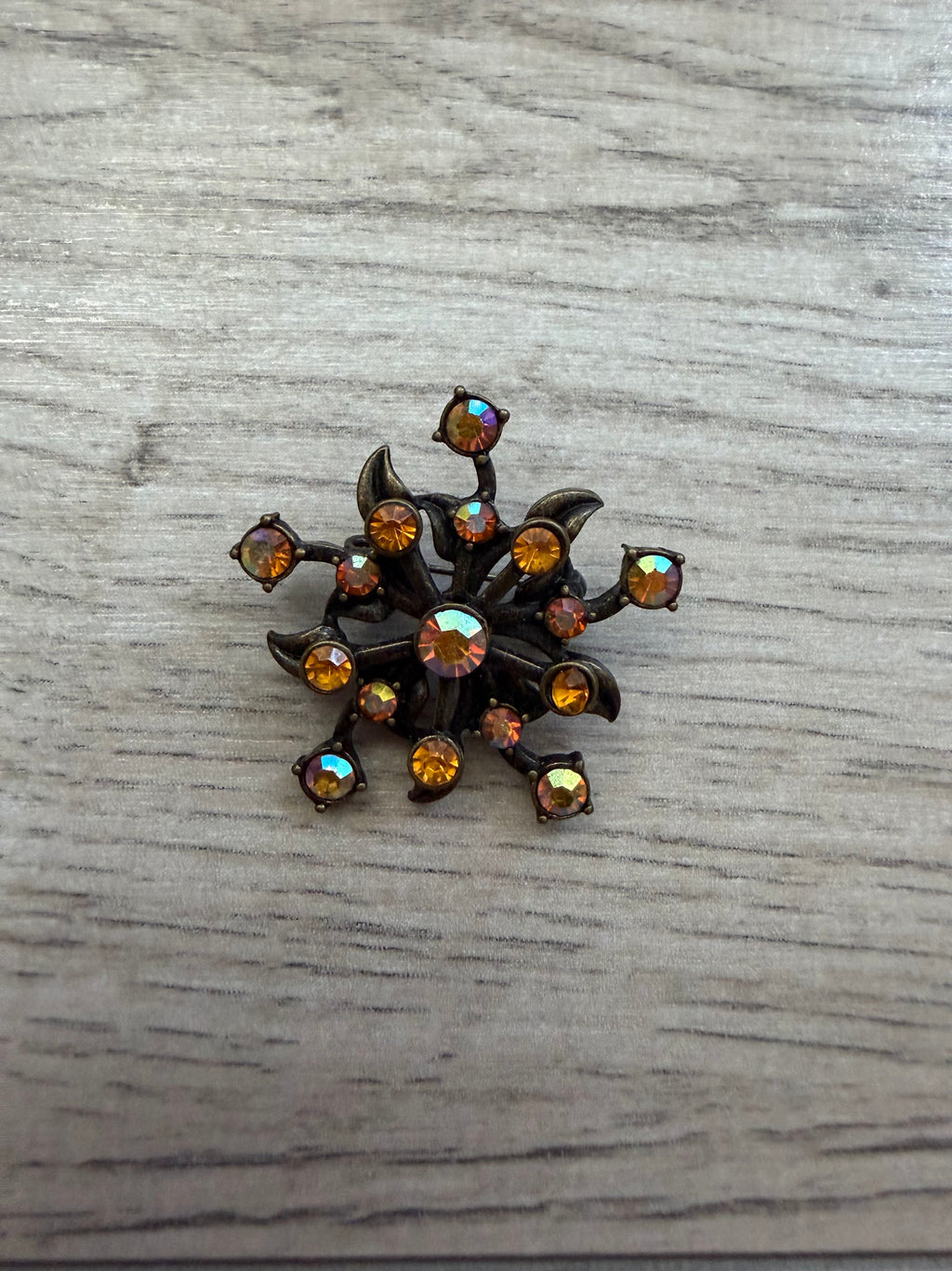 Vintage starburst brooch with amber and aurora borealis rhinestones