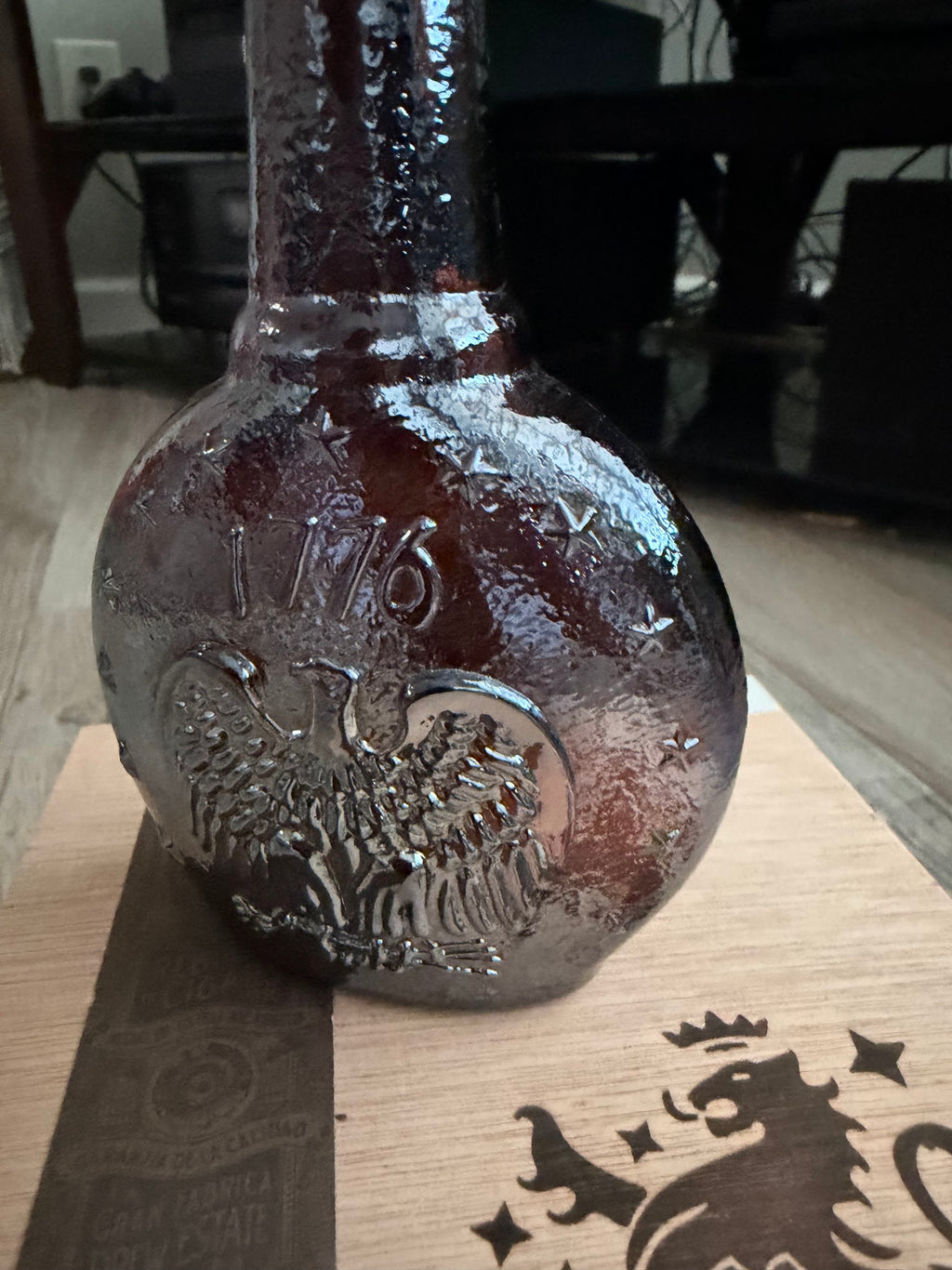 Close detail of 1776 and eagle embossing on textured amber glass