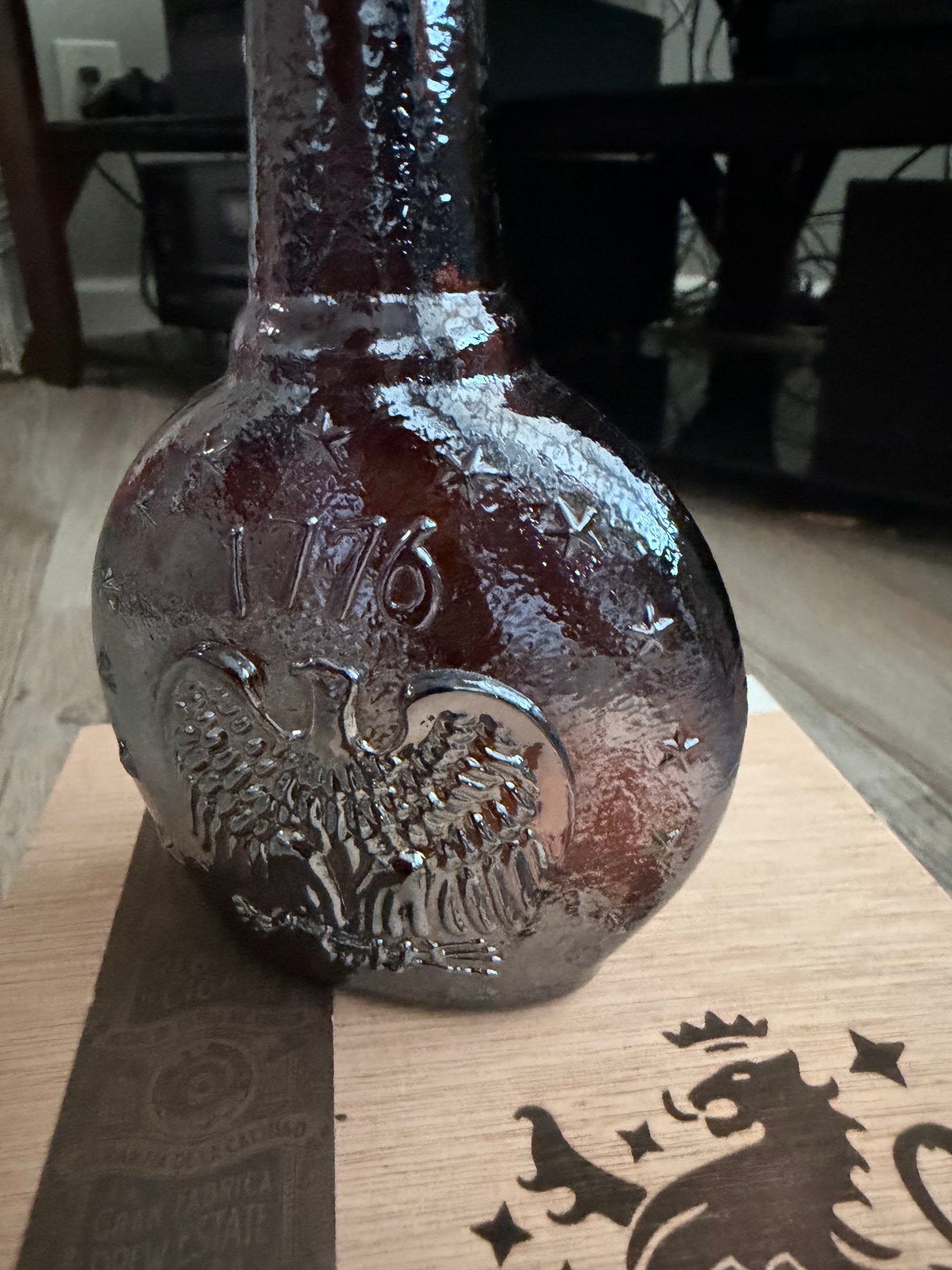 Close detail of 1776 and eagle embossing on textured amber glass