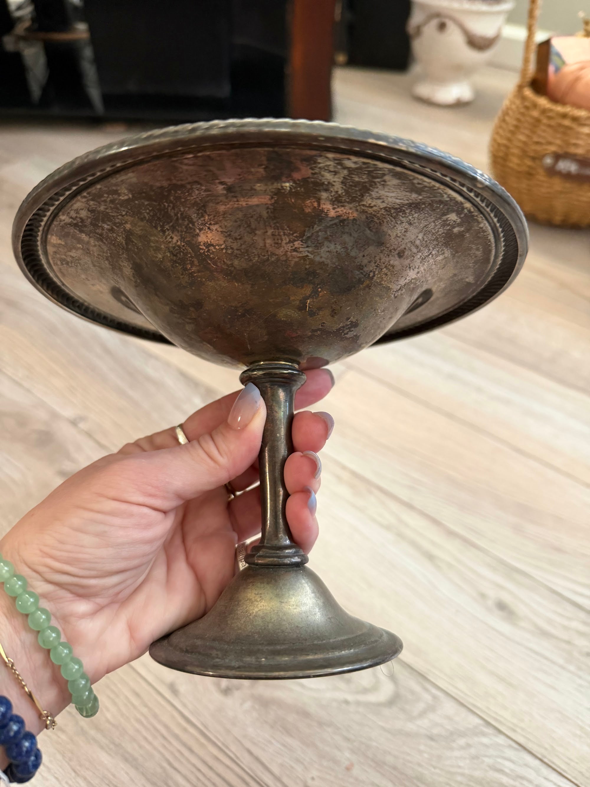 Hand holding silverplate compote showing trumpet pedestal base
